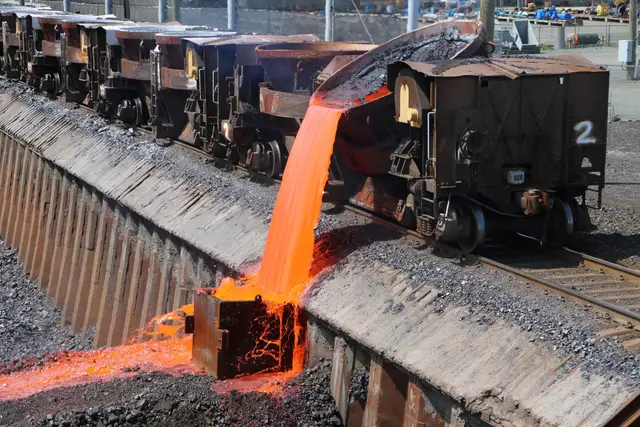 Molten slag pouring from a rail car into a trench