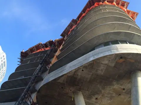 The tower under construction with curving concrete slab edges