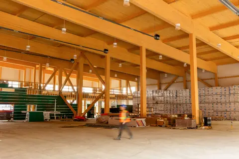 Double-height interior of the Cambrian Heights warehouse with glulam columns, beams and diagonal braces