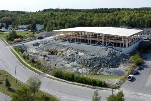 Aerial view of Cambrian Heights from the road, a long low building with a timber frame visible along the front