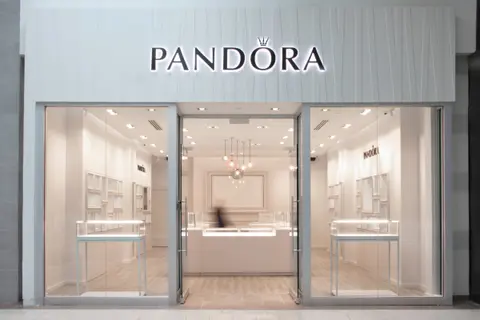 Pandora storefront with a white fascia and glazed entrance in a shopping mall