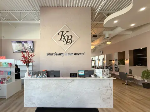 Reception desk in white marble in front of a feature wall with the KB logo