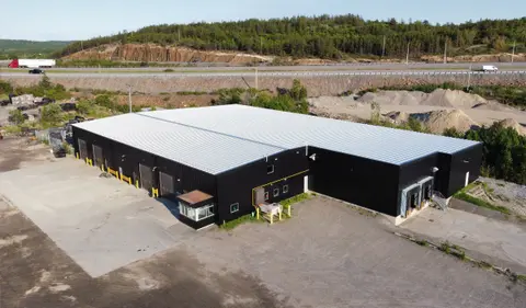 The existing industrial building after new dark metal cladding and roofing