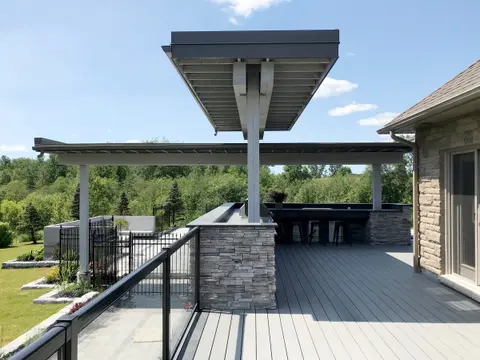 Outdoor kitchen under steel-framed canopies on a raised deck
